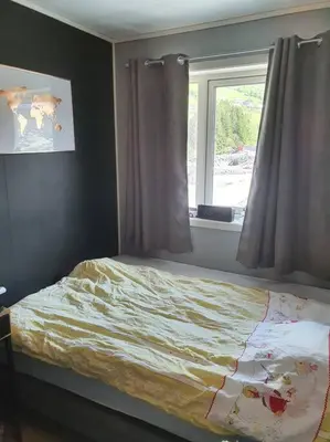a bedroom with a bed and a window at Nydelig leilighet- Solrik/2 balkonger in Seim