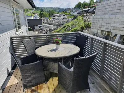 a table and chairs on a balcony with a table and flowers at Nydelig leilighet- Solrik/2 balkonger in Seim