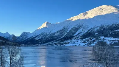 a view of a mountain with a river and snow at Panorama #CasaSolvik #Loen in Loen