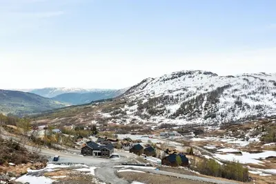 a small village in the mountains with snow at Rindabakkane Lodge in Sogndal