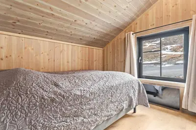 a bedroom with a bed and a window at Rindabakkane Lodge in Sogndal