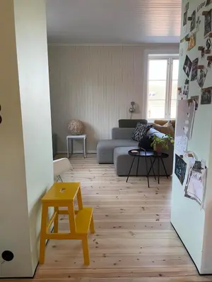 a living room with a couch and a table at Tomannsbolig på Rosenborg in Trondheim