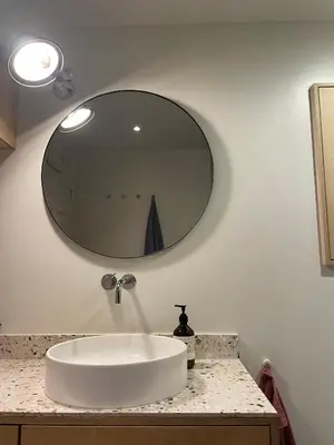 a bathroom with a white sink and a mirror at Tomannsbolig på Rosenborg in Trondheim