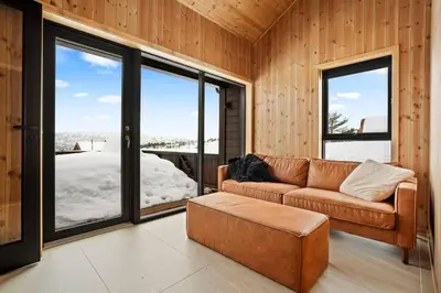 a living room with a couch and large windows at Tonningssætra Mountain Lodge in Stryn