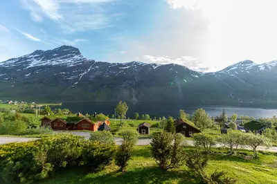 a village with a lake and mountains in the background at Cabin near the lake in Årset