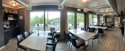 a restaurant with tables and chairs and a large window at Kårdal Fjellstove in Mjølfjell