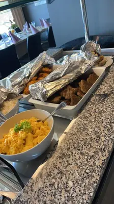 a buffet with plates of food and a bowl of food at Kårdal Fjellstove in Mjølfjell