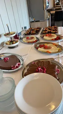 a table topped with white plates and chocolate desserts at Kårdal Fjellstove in Mjølfjell