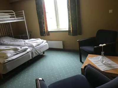 a room with a bed and a chair and a table at Kårdal Fjellstove in Mjølfjell