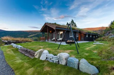 a house with a swing in front of it at Luxury cabin in the mountains with all facileties in Sønstebø
