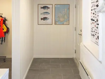 a hallway with a tile floor and pictures on the wall at 8 person holiday home in averøy-By Traum in Averoy