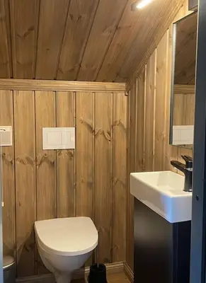 a bathroom with a white toilet and a sink at Hjemmekoselig hytte på Rauland in Rauland