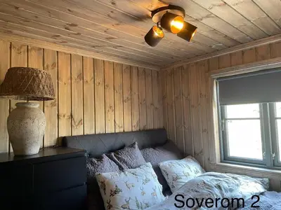 a bedroom with a bed and a ceiling fan at Hjemmekoselig hytte på Rauland in Rauland