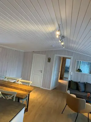 a living room with a couch and a table and chairs at Holiday home in beautiful Sjusjøen, near Lillehammer in Ringsaker