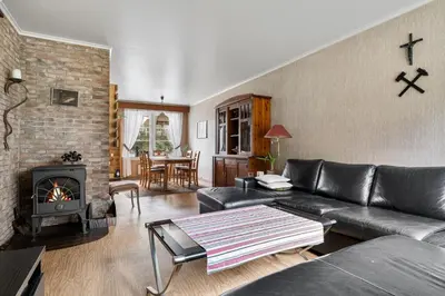 a living room with a leather couch and a fireplace at Tysso Apartment in Tveit