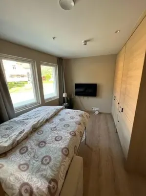 a bedroom with a large bed and a large window at Studio Leiligheit in Sogndal