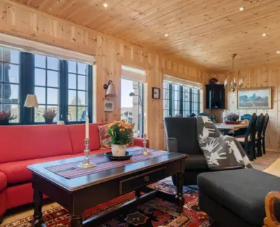 a living room with a red couch and a table at Leilighet sentralt på Beitostølen in Beitostøl