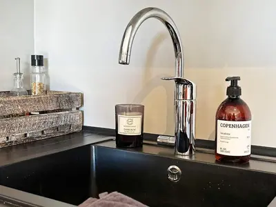 a sink with a bottle of alcohol and a glass at 4 person holiday home in GEILO-By Traum in Geilo