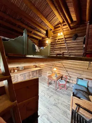 a room with a table and a bench in a cabin at Traditional barn -Stabbur - wifi og sauna in Baukål