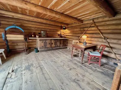 a room with a table and chairs in a log cabin at Traditional barn -Stabbur - wifi og sauna in Baukål