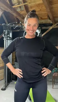 a woman in black shirt and leggings standing in a gym at Monshaugen Home - Privat Retreat in Sykkylven