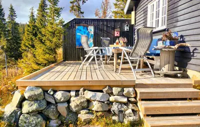 a deck with a table and chairs on a house at 2 Bedroom Awesome Home In Lillehammer in Lillehammer