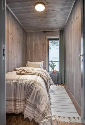 a bedroom with wooden walls and a bed with a window at 7 Min to Fjord - Alpine Stay in Stranda in Stranda