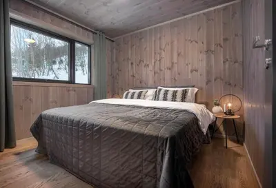 a bedroom with a bed in a room with a window at Ground Floor Exclusive Apartment with Sauna - Near Geiranger and the Norwegian Fjords in Stranda