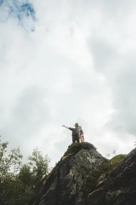 a person standing on top of a rock at Ground Floor Exclusive Apartment with Sauna - Near Geiranger and the Norwegian Fjords in Stranda