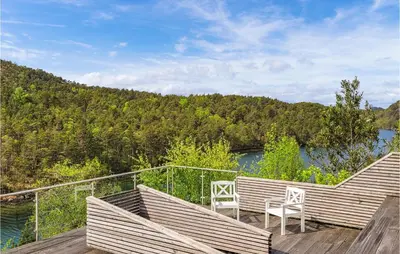 a deck with two chairs and a view of a river at Beach Front Home In Førde I Hordaland in Erve