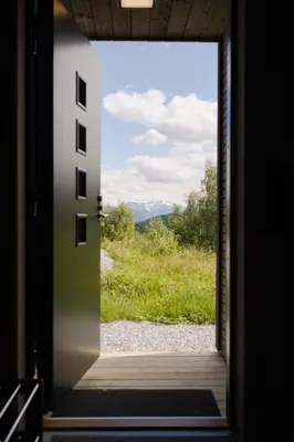 an open door with a view of a field at Exclusive Nordic Apartment with Sauna - Prime Location at Stranda near Geiranger in Stranda