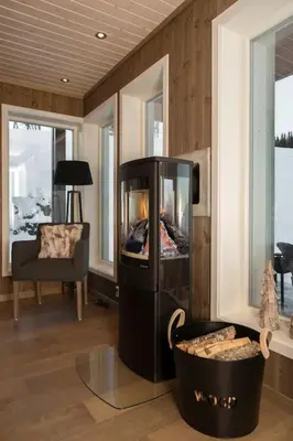 a living room with a fireplace and a chair at Bualie - Golsfjellet - Biking, swimmming, hiking. High standard. in Gol