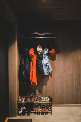 a closet with a rack of clothes and shoes at Nordic Luxury Apartment - Private Sauna & Panoramic Mountain Views in Stranda