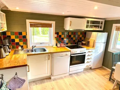 a small kitchen with white cabinets and a sink at 4 person holiday home in OMASTRAND-By Traum in Sanddal