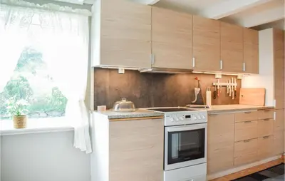 a kitchen with wooden cabinets and a stove top oven at Beautiful Home In Sveio With Wifi in Sveio