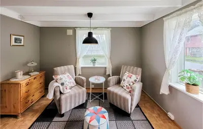 a living room with two chairs and a table and a window at Beautiful Home In Sveio With Wifi in Sveio