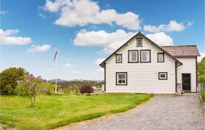 a white house with a flag in a yard at Beautiful Home In Sveio With Wifi in Sveio
