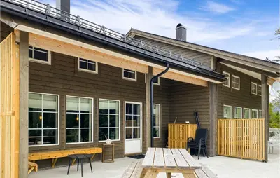 a house with a deck with a table and chairs at Amazing Home In Nordfjordeid With Wifi in Nordfjordeid