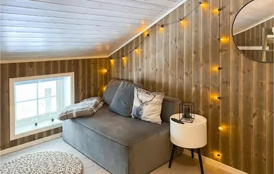 a couch in a room with wooden walls at Amazing Home In Nordfjordeid With Wifi in Nordfjordeid