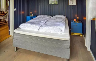 a large bed in a room with blue walls at Nice Home In Tuddal With Kitchen in Tuddal