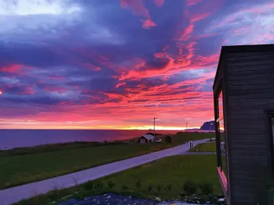 a sunset view of a house and a road at Beach front appartments in design eco-villa in Ulsteinvik