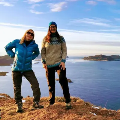 two people standing on a hill near the water at Beach front appartments in design eco-villa in Ulsteinvik