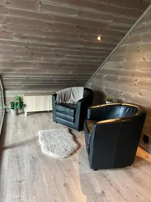a living room with two leather chairs and a rug at Rindabotten Panorama in Sogndal
