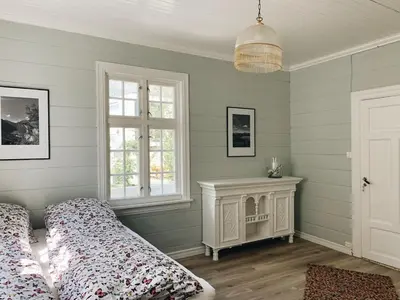 a bedroom with green walls and a bed and a fireplace at Valldal Sentrum Overnatting in Valldal