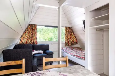 a small living room with a couch and a window at Hallingparken in Gol