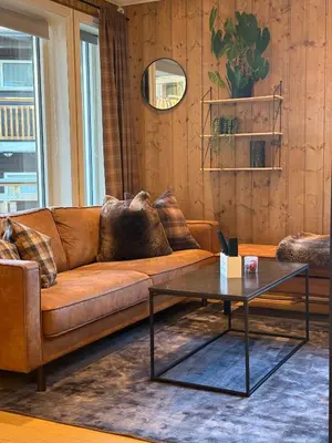 a living room with a brown couch and a coffee table at Nice apartment on Geilotunet, Close to city center in Geilo