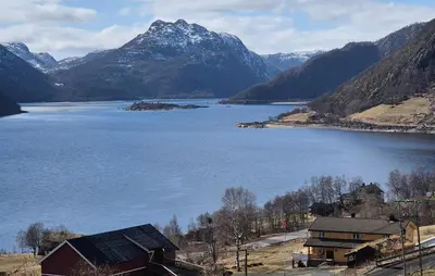 a view of a lake with a barn and mountains at Nice Home In Rauland With Kitchen in Rauland