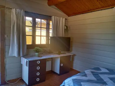 a bedroom with a desk and a bed and a television at LUBBENES GÅRD in Molde