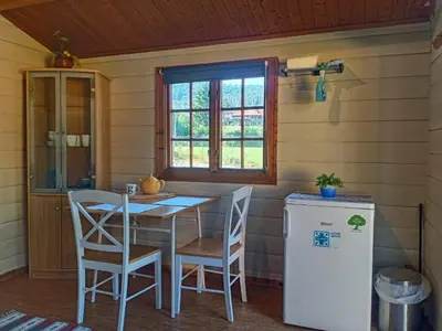 a kitchen with a table and chairs and a refrigerator at LUBBENES GÅRD in Molde