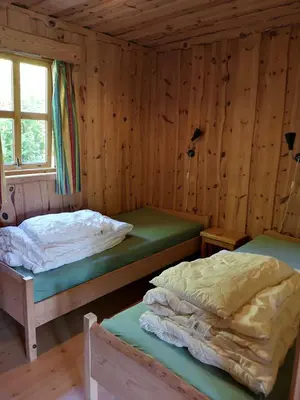 two beds in a room with wooden walls at Fanafjorden Cabins in Bergen